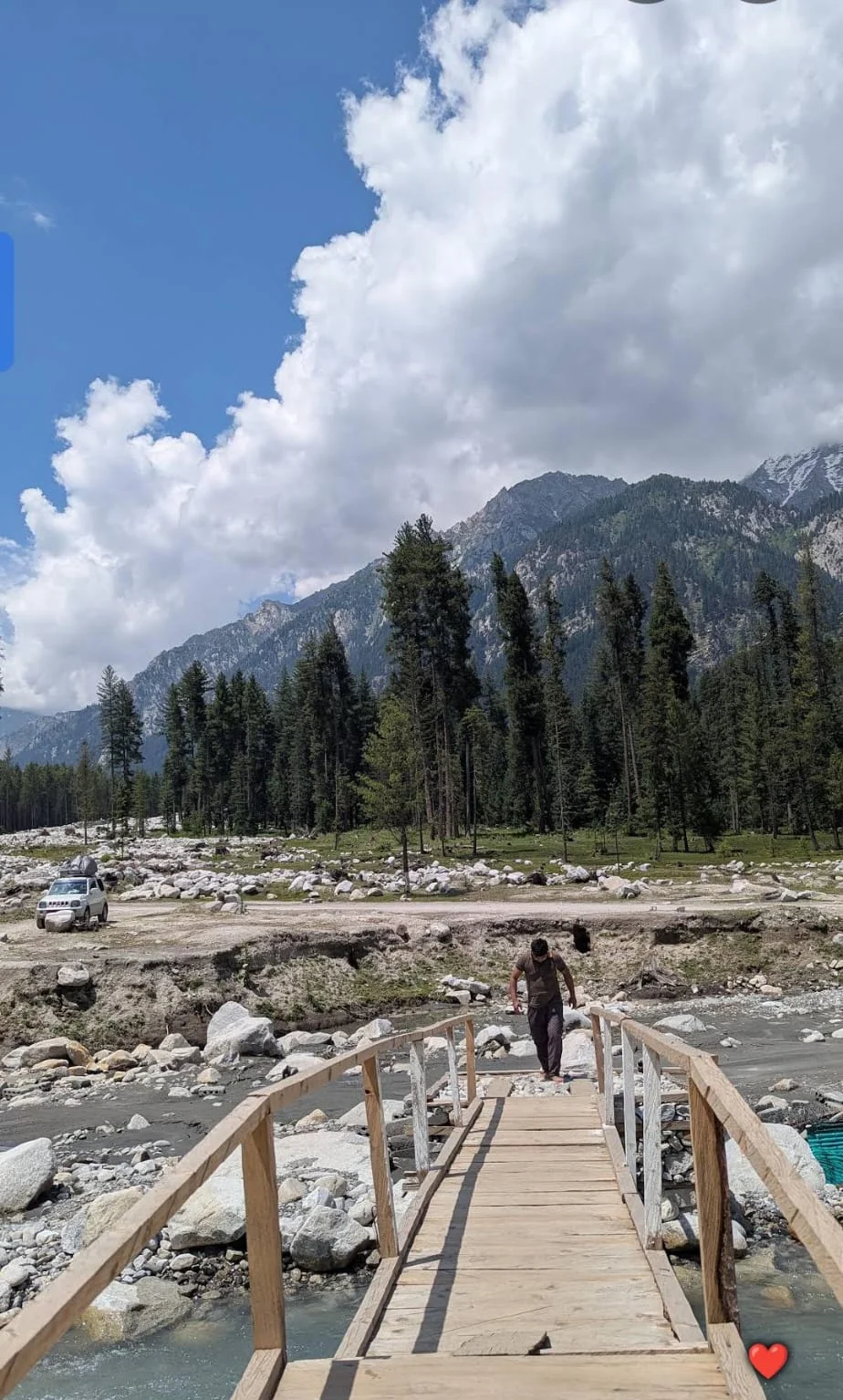 A small wooden footbridge beside the river in Kumrat